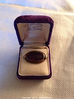 Amethyst brooch set in purple velvet box with satin interior, marked Nettleton Diamonds Ottawa inside lid.