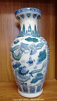 Porcelain vase front view showing dragon and cloud designs with floral and geometric patterns.