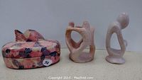 Three hand carved stone decor items: fish-shaped box with lid and two abstract sculptures.