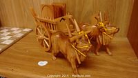 Wood carved oxen cart with two oxen and visible wooden coasters on the top shelf.
