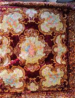 Full view of the vintage Italian silk velvet bedspread with ornate relief and colorful painted panels set in burgundy velvet.