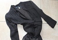 Top and front view showing pleated black gauze fabric, long sleeves, and the rope belt tied at the waist.