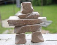 Front view of the pink soapstone Inukshuk sculpture showing the stacked geometric shapes.