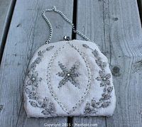 Vintage silver beaded evening bag with central star design on wooden surface
