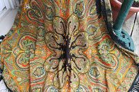 Close-up image showing detailed paisley pattern with black fringe on the edges of the shawl.