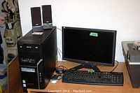 Acer desktop computer tower, Acer monitor, wired keyboard, wireless mouse, and Insignia speakers on a desk.