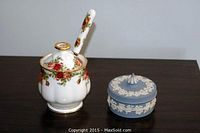 Photo showing Royal Albert Old Country Roses sugar jar with lid and decorative spoon, alongside a Wedgwood blue jasperware jar with lid showing white relief floral decoration.