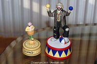 View of two musical clown figurines by Emmett Kelly Jr. displayed on a table, showing size and detail.