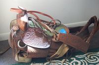 Full side view of the leather Western saddle showing overall shape and tooling