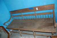 Full view of pew against blue wall showing seat, backrest, and armrest shape
