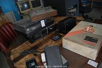 Wide view of all audio equipment including turntable, multitracker in box, and other devices on table.