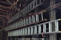 Three extension ladders hung horizontally on barn wall, showing full lot