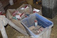Multiple cardboard boxes and plastic bin filled with door knob boxes and hardware parts.