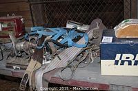 Various bridles in multiple colors including blue, beige, and brown, some leather with metal buckles, laid on a table