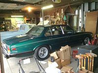 Side profile of green Jaguar XJ6 in garage
