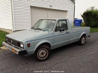 Front three-quarter view showing light blue faded paint, front grille, headlights, bumper and driver’s side mirror