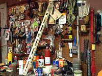 Pegboard wall with hanging hardware packs, level, cord, hooks and assorted small tools