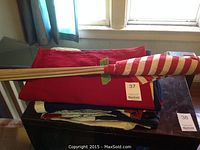 Stack of folded flags with wooden poles wrapped in red and white fabric