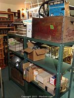 Overall shelf view showing stacked magazines, manuals, wooden Pepsi crate and boxes