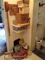 Corner shelf with stacked boxes and various boxed items, drinking glasses and trays visible