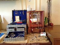 Overall display of jewelry in two fabric-lined boxes and on tabletop