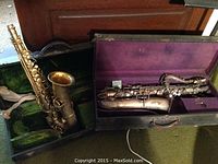 Two saxophones in separate lined hard cases side by side