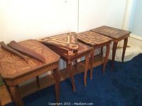 Five tables lined up against wall, including triangular top disassembled pieces