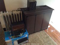 Photo showing a DeLonghi oil-filled radiator heater, a smaller dark Welbilt Ceramix heater with controls, and a JC Penney dehumidifier behind them.