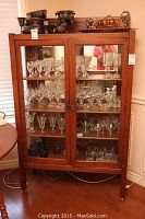 Front view of oak and glass china cabinet showing double glass doors and four shelves