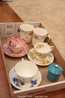 Overall lot view showing three tea cup and saucer sets, two mugs, sugar pot