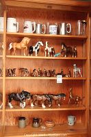 Full shelving unit showing steins on top and horse figurines