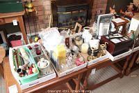 Wide shot showing three trays with assorted items on a table including candles, brass candle holders, and other decorative pieces