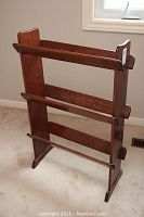 Front view of wooden bookcase showing three horizontal rails and curved top edges on side panels.