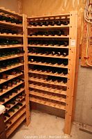 Pine wooden wine rack with multiple slatted shelves, some holding bottles