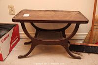 Full view of rectangular Duncan Phyfe style side table showing curved legs, stretcher, and water stained top surface.