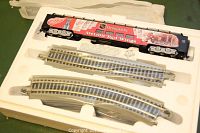 Train car in foam packaging with included curved and straight metal train tracks visible.