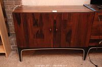 Front view of the wood cabinet with two doors and curved base, showing wood grain and polished finish.