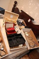 Overview showing wooden jewelry box on bed frame, black plastic tray, red velvet box, white box and cardboard box of jewelry