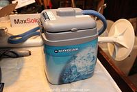 Full view of the Polar Care Kodiak cold therapy unit, showing the blue and grey body and attached hose.