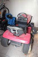 Front view of red Canadian Tire riding mower showing seat and steering wheel