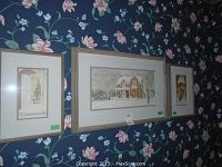 Three framed signed prints by Walter Campbell on floral wallpapered wall