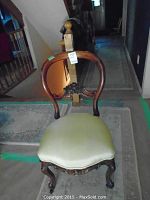 Full chair front view showing its curved wooden backrest and upholstered seat.