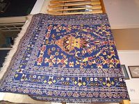 Top view of entire rug draped over stair rail showing pattern and fringe