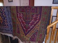 Full view of the runner rug draped over a wooden railing showing overall geometric design and color scheme.
