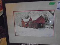 Framed lithograph print depicting red coach house in snowy landscape with white and red double mat in black wood frame.