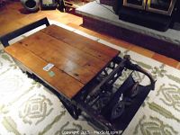 Overall view of coffee table showing wooden top and cast iron scale base