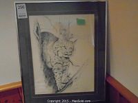 Photo of framed print showing the bobcat climbing a tree graphic in black and white sketch style.