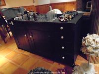 Front view of painted wood dry sink showing three drawers on right and double cabinet doors on left