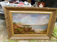 Frontal view of the oil painting with ornate carved frame showing the landscape scene.