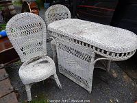 Early white wicker breakfast table with two matching chairs, showing wear and damage on chairs